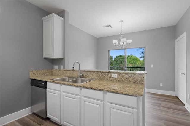 kitchen featuring a peninsula, dishwasher, baseboards, and a sink