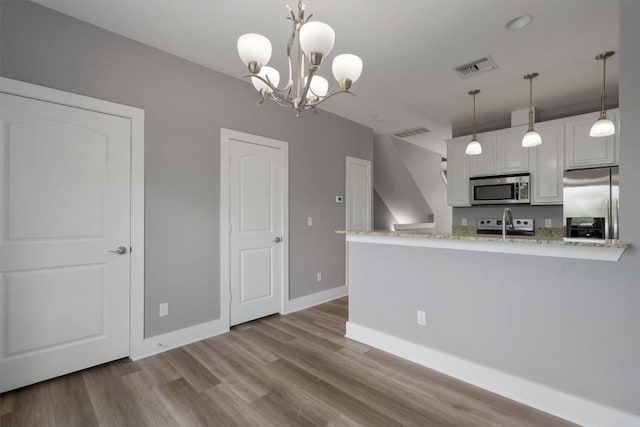 kitchen with white cabinets, wood finished floors, visible vents, and stainless steel appliances