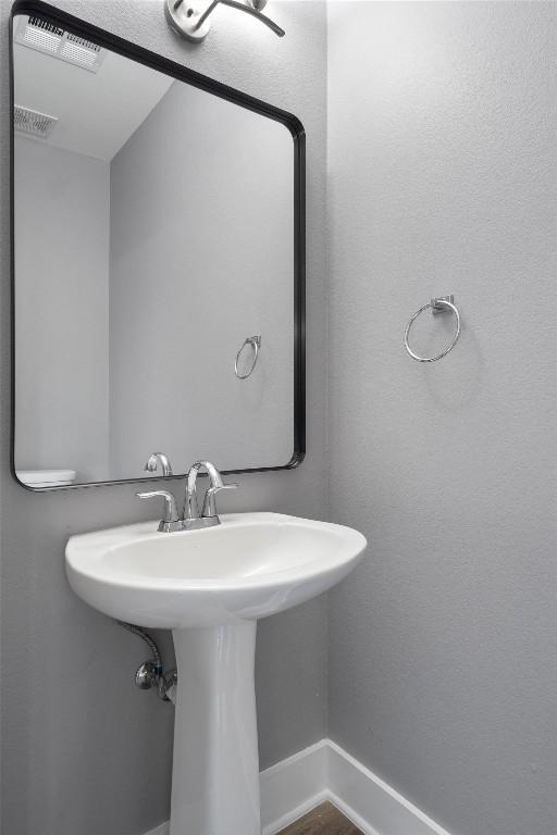 bathroom with visible vents, baseboards, and a sink