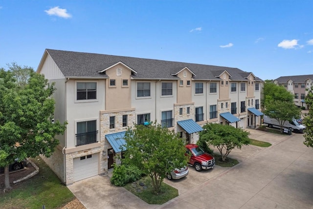 view of property with an attached garage, driveway, and a residential view
