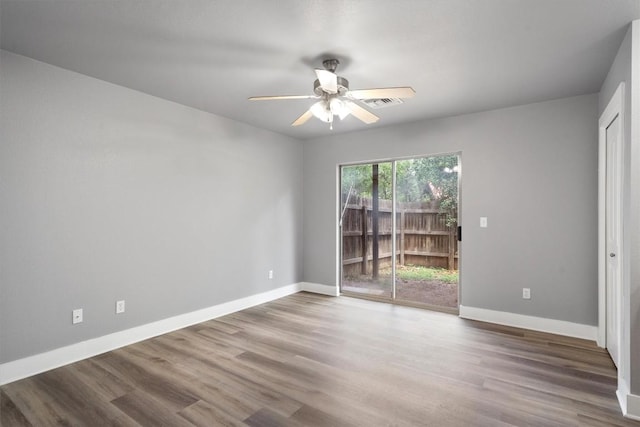 interior space featuring baseboards, access to outside, wood finished floors, and visible vents