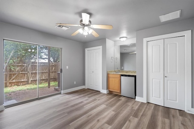 interior space featuring fridge, visible vents, a ceiling fan, and light wood-style flooring