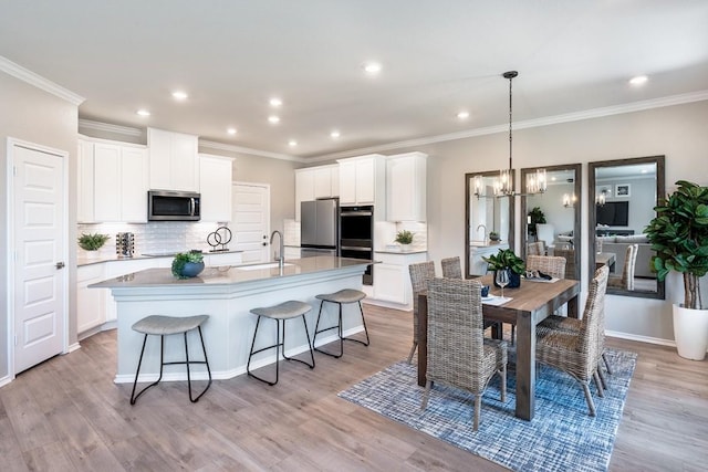 1100 Cole Estates Dr, Georgetown, TX 78628 - kitchen with decorative backsplash, crown molding, a chandelier, stainless steel appliances, and a kitchen island with sink
