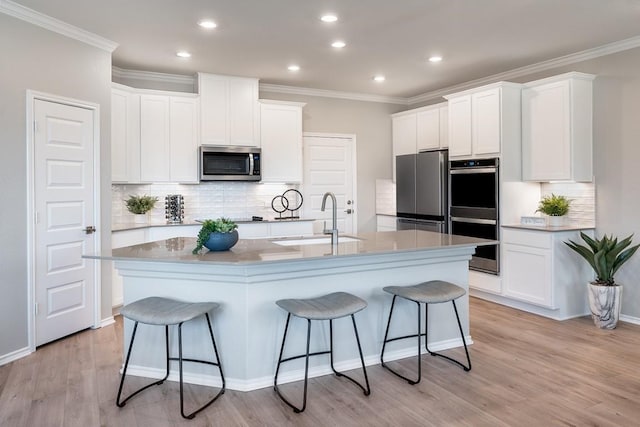 1100 Cole Estates Dr, Georgetown, TX 78628 - kitchen featuring a breakfast bar, backsplash, appliances with stainless steel finishes, and a sink