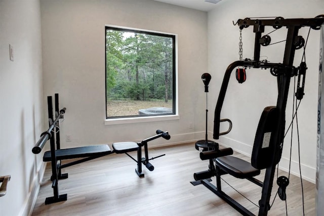 workout area with light wood-type flooring and baseboards