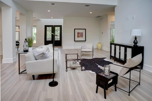 living room featuring baseboards, a healthy amount of sunlight, wood finished floors, and visible vents