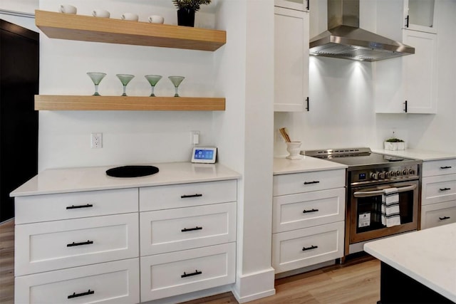 kitchen with wall chimney exhaust hood, white cabinetry, open shelves, and stainless steel electric range oven
