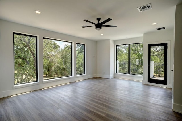 unfurnished room with baseboards, visible vents, and a wealth of natural light