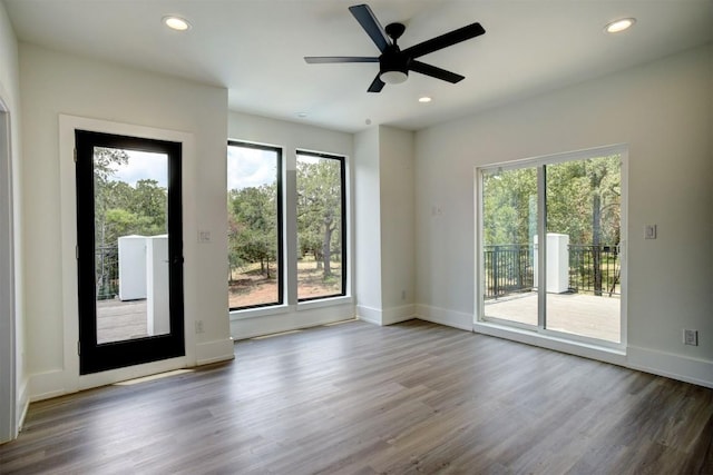 empty room featuring recessed lighting, plenty of natural light, and wood finished floors