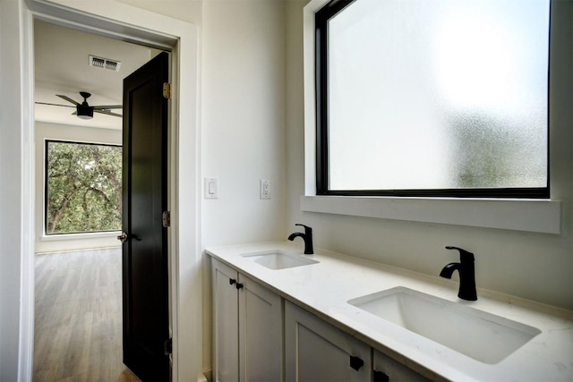 bathroom with double vanity, visible vents, a ceiling fan, and a sink
