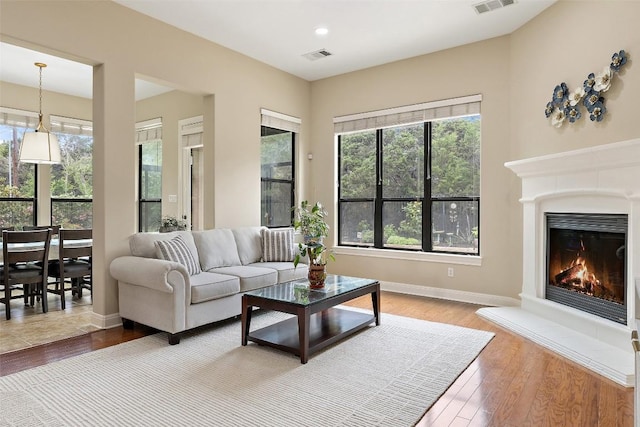 2328 Gilia Dr, Austin, TX 78733 - living room with wood finished floors, a warm lit fireplace, and recessed lighting