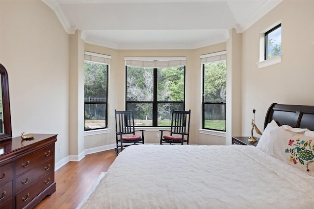bedroom featuring crown molding, wood finished floors, and multiple windows