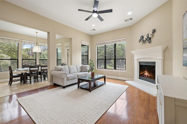 2328 Gilia Dr, Austin, TX 78733 - living room featuring a lit fireplace, ceiling fan, hardwood / wood-style floors, and recessed lighting