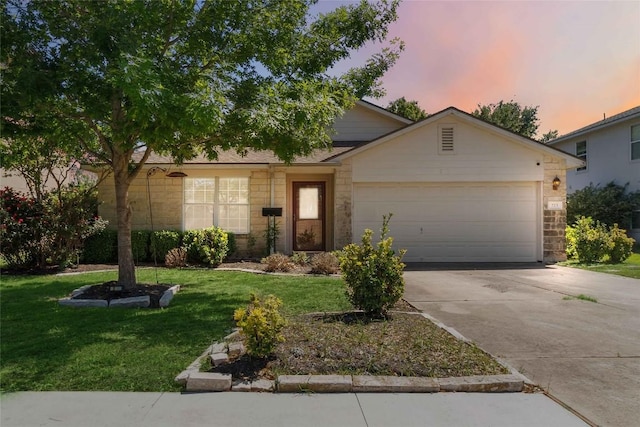 223 Sylvan St, Hutto, TX 78634 - view of front of house with a yard, an attached garage, driveway, and stone siding