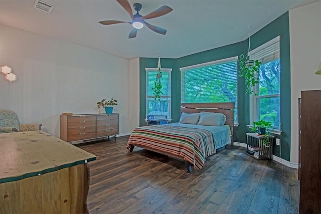 bedroom featuring hardwood / wood-style flooring, baseboards, a ceiling fan, and visible vents