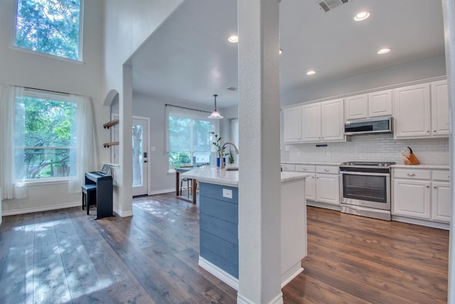 kitchen featuring white cabinets, light countertops, appliances with stainless steel finishes, and dark wood-style flooring