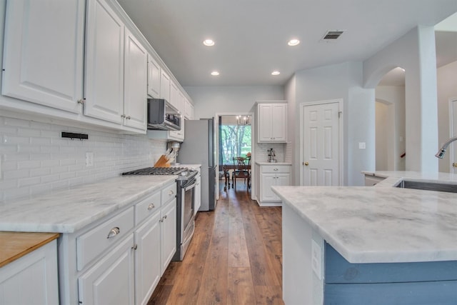 kitchen featuring white cabinets, stainless steel appliances, visible vents, and a sink