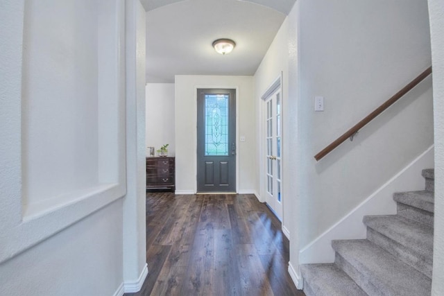 foyer featuring baseboards, stairs, and dark wood-style floors