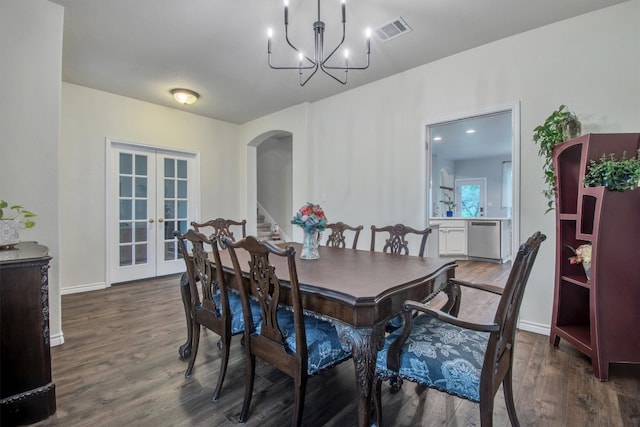 dining area with wood finished floors, visible vents, french doors, arched walkways, and a notable chandelier