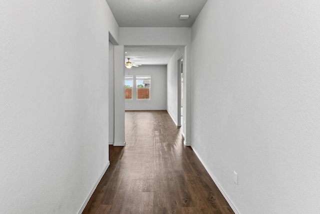 corridor featuring wood finished floors and baseboards
