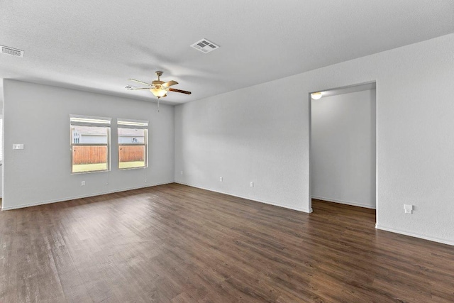 unfurnished room featuring visible vents, ceiling fan, and dark wood finished floors
