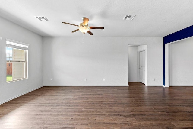 unfurnished room featuring wood finished floors, visible vents, and ceiling fan