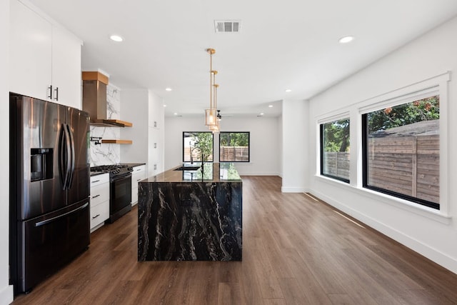 7008 Meador Ave Unit 1, Austin, TX 78752 - kitchen featuring dark wood finished floors, black gas range oven, wall chimney range hood, open shelves, and stainless steel refrigerator with ice dispenser