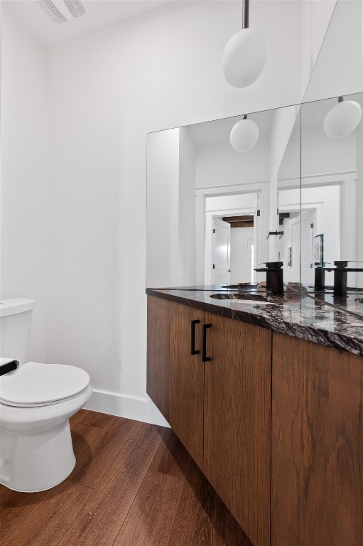7008 Meador Ave Unit 1, Austin, TX 78752 - bathroom featuring wood finished floors, vanity, toilet, and baseboards