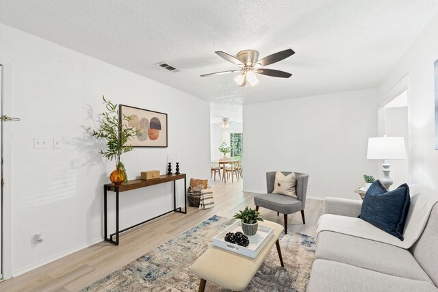 512 Sheraton Ave, Austin, TX 78745 - living area featuring ceiling fan, light wood-style floors, a textured ceiling, and baseboards