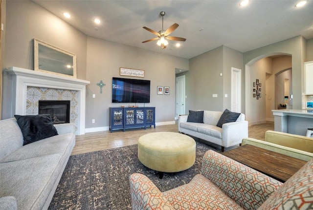 living area featuring recessed lighting, arched walkways, a ceiling fan, and a fireplace
