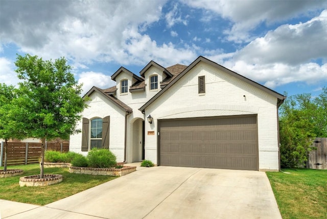 view of front of house featuring brick siding, fence, and driveway