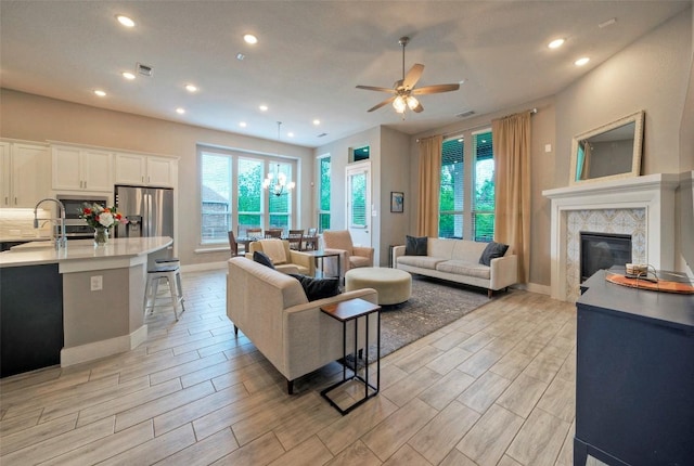 2012 Matlock Cir, Hutto, TX 78634 - living area featuring plenty of natural light, ceiling fan, a premium fireplace, light wood-style flooring, and recessed lighting