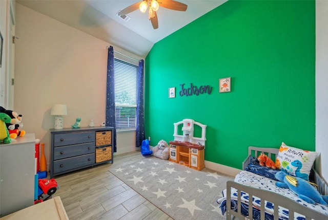 bedroom featuring lofted ceiling, ceiling fan, visible vents, baseboards, and wood finished floors