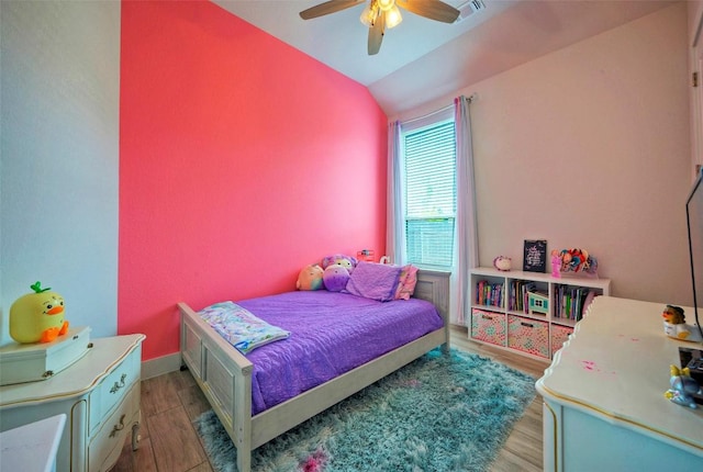 bedroom featuring lofted ceiling, wood finished floors, ceiling fan, and visible vents