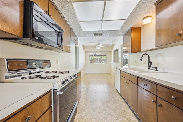 kitchen featuring a sink, visible vents, light countertops, white appliances, and brown cabinetry