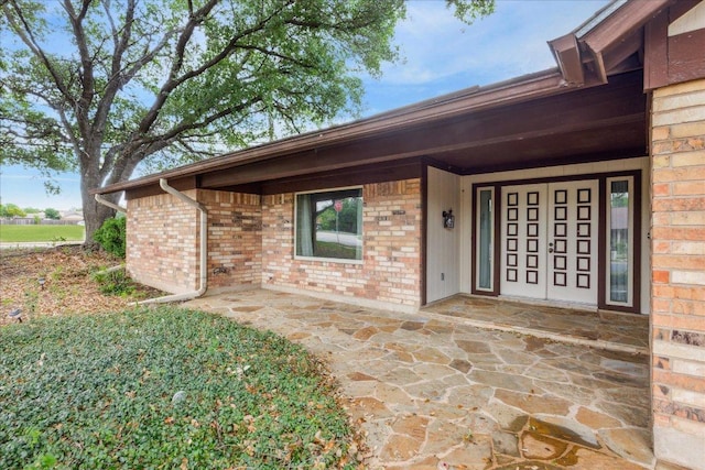 view of exterior entry featuring brick siding