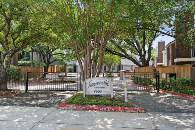 community sign featuring a gate and fence