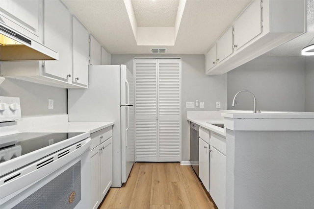 kitchen featuring light wood-style floors, under cabinet range hood, light countertops, white range with electric stovetop, and visible vents