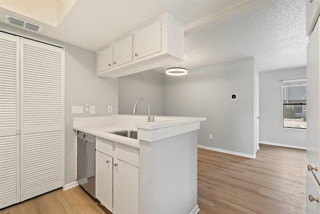 kitchen with baseboards, visible vents, light wood-type flooring, and dishwasher