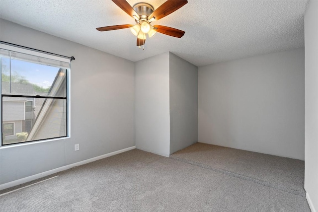 carpeted spare room featuring ceiling fan and a textured ceiling
