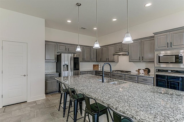 1801 Lakeside Ranch Rd, Georgetown, TX 78633 - kitchen with a sink, appliances with stainless steel finishes, light stone countertops, decorative backsplash, and recessed lighting