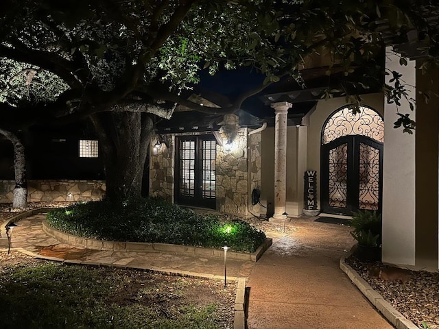 doorway to property with stone siding and french doors