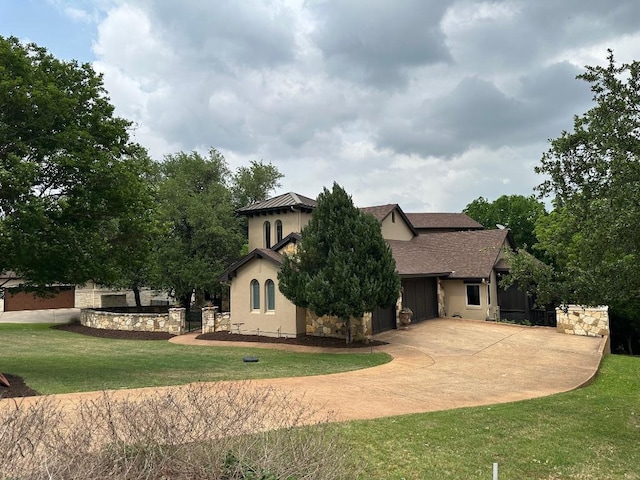view of front of home with concrete driveway, a front yard, and a garage