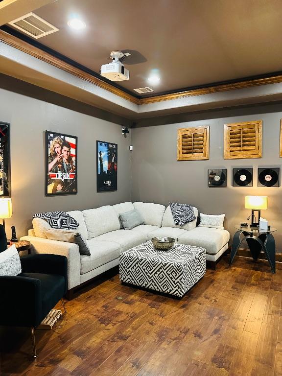 2749 Springwood Ln, Georgetown, TX 78628 - cinema room featuring ornamental molding, a raised ceiling, wood-type flooring, and recessed lighting