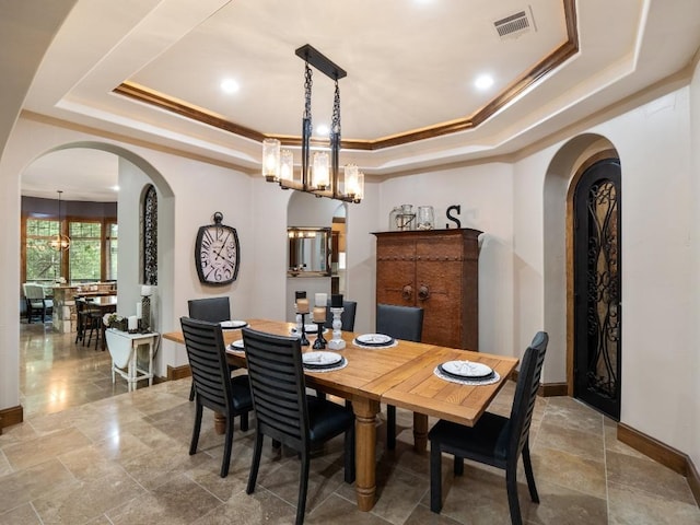 2749 Springwood Ln, Georgetown, TX 78628 - dining area featuring a raised ceiling, arched walkways, a chandelier, baseboards, and ornamental molding