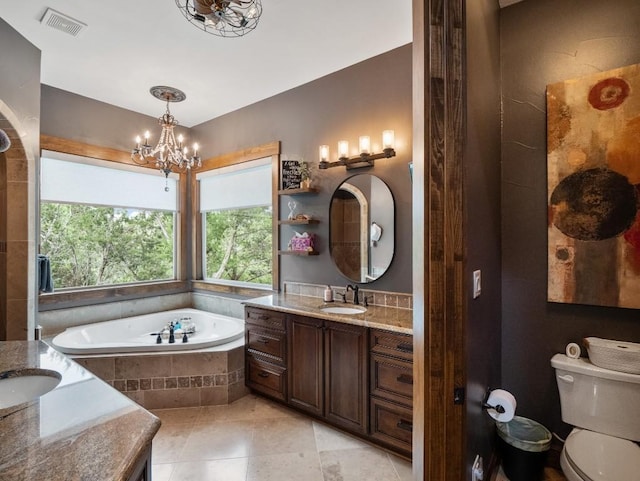 bathroom with an inviting chandelier, visible vents, a healthy amount of sunlight, and a garden tub