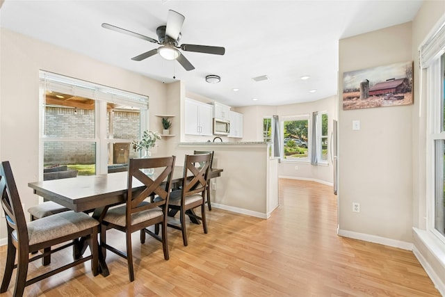 dining room with light wood-type flooring, a ceiling fan, recessed lighting, and baseboards
