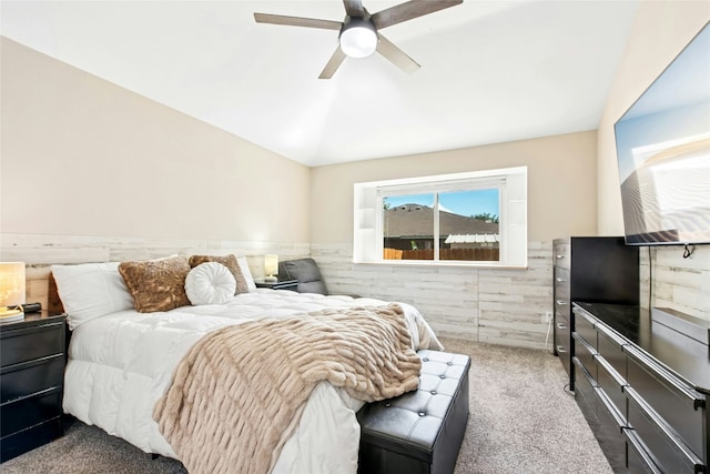 bedroom with wainscoting, a ceiling fan, carpet, and vaulted ceiling