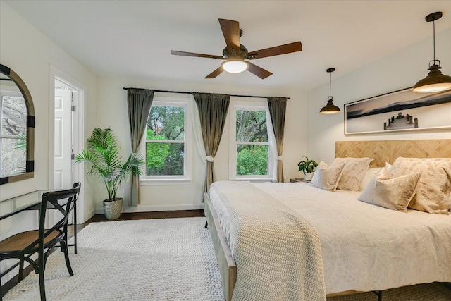 bedroom featuring baseboards, a ceiling fan, and wood finished floors