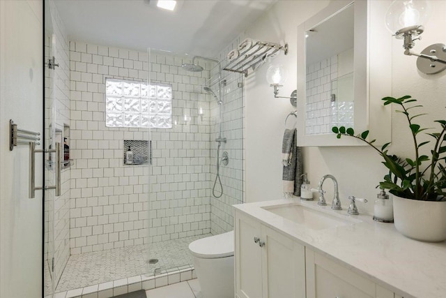 full bath with tile patterned floors, vanity, toilet, and a stall shower